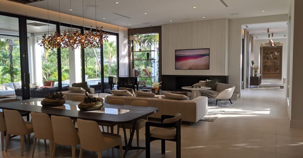 View of kitchen and living area with modern lighting, large sofa and flat screen TV on the back wall