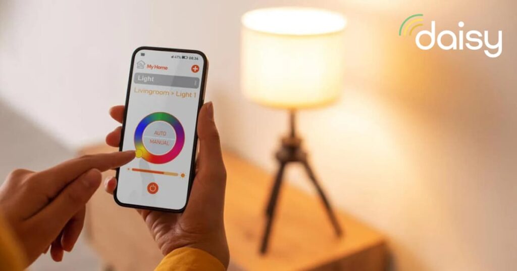 Person holding smart phone showing a color wheel on the screen and a lamp on a table in the background