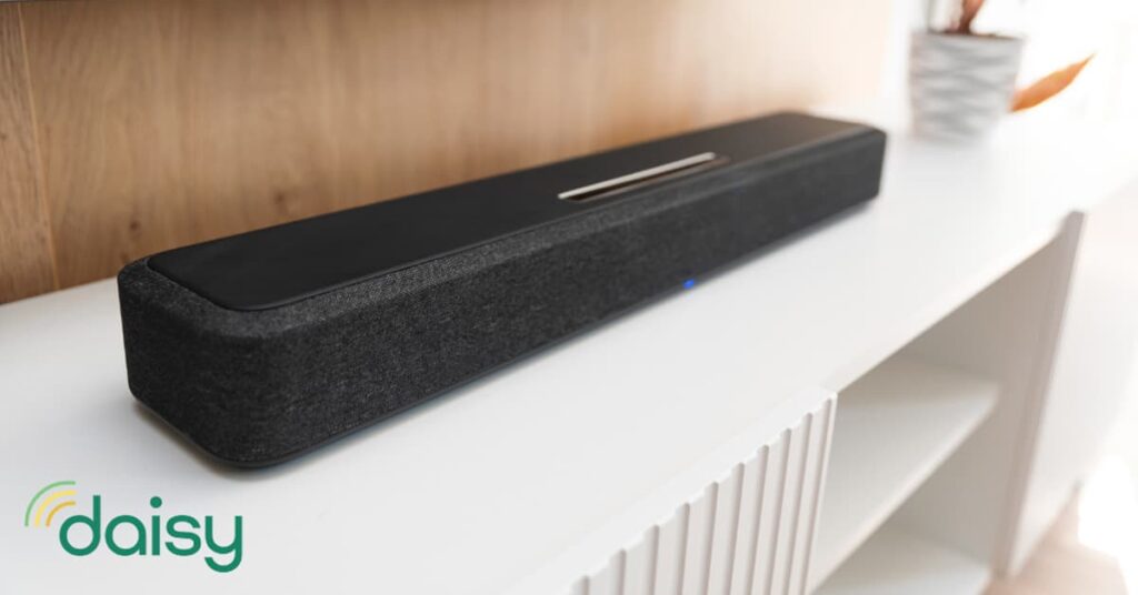Sound bar on a white bookcase next to a brown wall