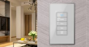 Lighting control switch on wall with other room on the left and a chandelier in the back