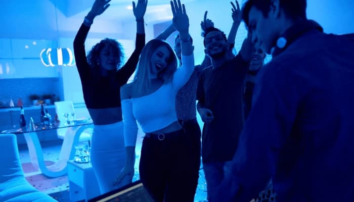 A group of young people dancing to music with reactive lighting