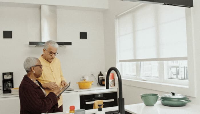 Older couple figuring out how their smart blinds work through the app on their tablet