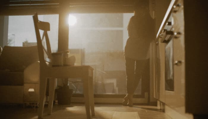 Woman stands in front of windows as they open with the sun; windows are fully exposed to the sun