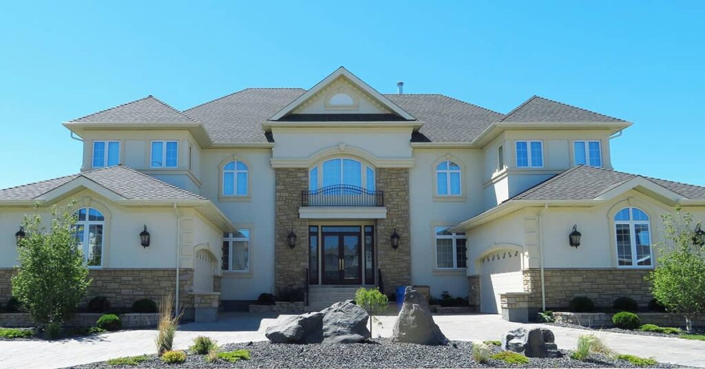 Front of large house with rock landscaping in the front of it