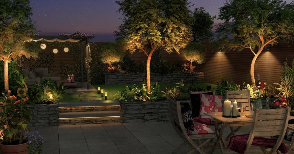 Nighttime view of backyard with patio and table with soft lighting overhead