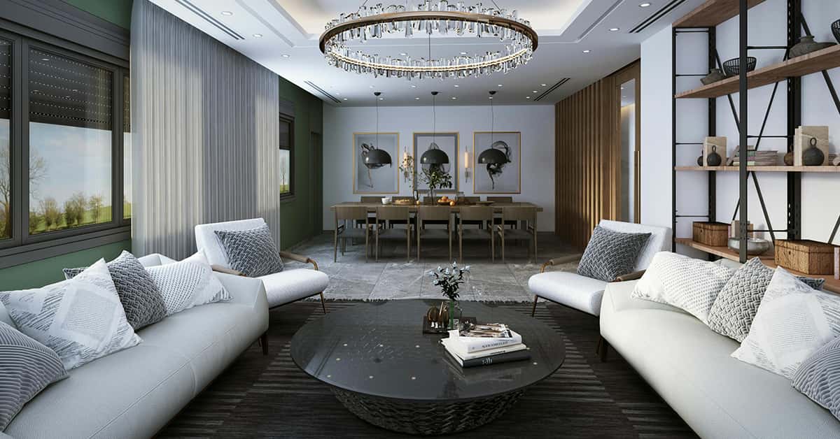 Living area with two white couches on either side of a dark round coffee table with shelves to the right and a dining area and table in the rear