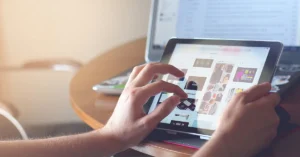 Person using a tablet PC in front of a laptop PC