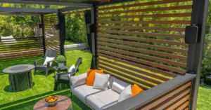 Sonance Mariner MX Outdoor speakers in an outdoor lounge area with a table, chairs, and a couch